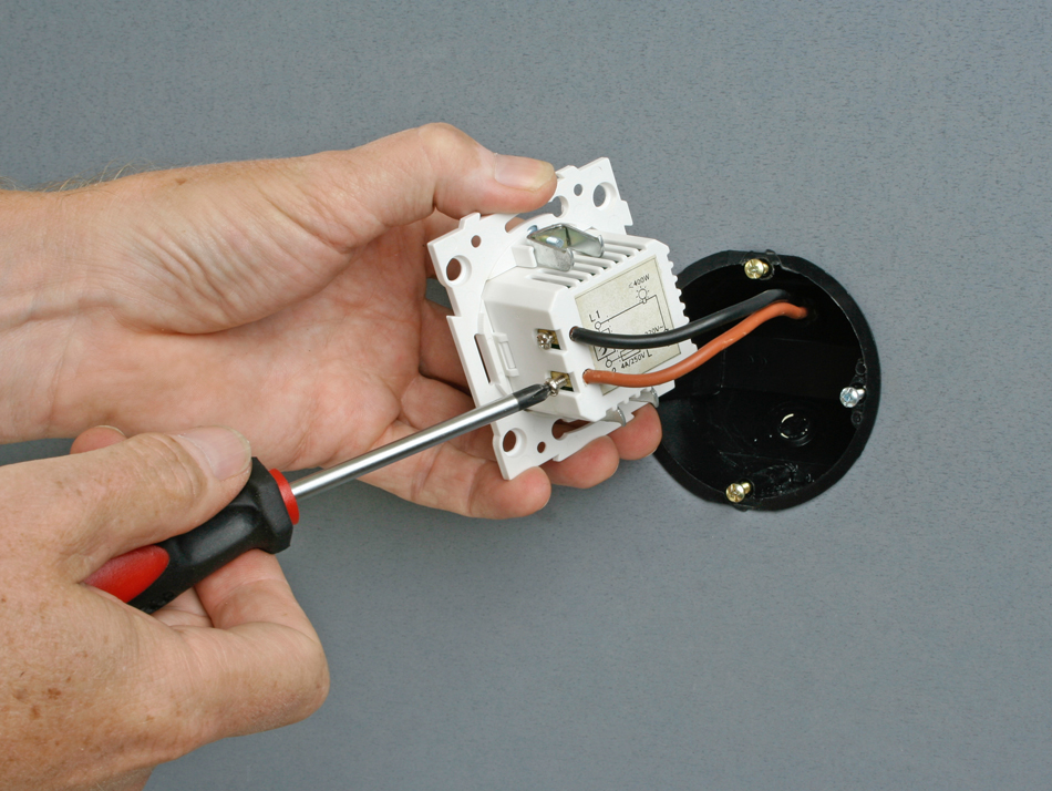 Electrician-installing-a-dimmer-switch-in-a-wall-socket-531927562 Electrician installing a dimmer switch in a wall socket